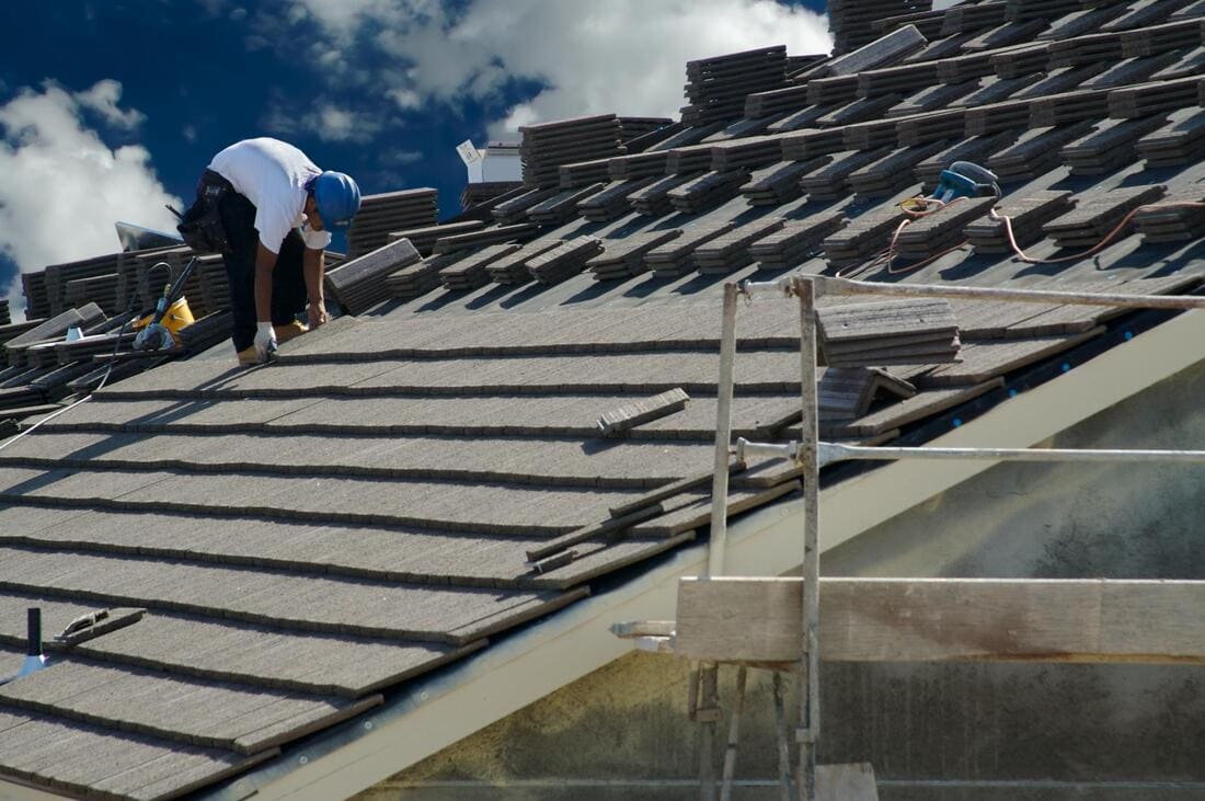 Roofers installing roof material over battens